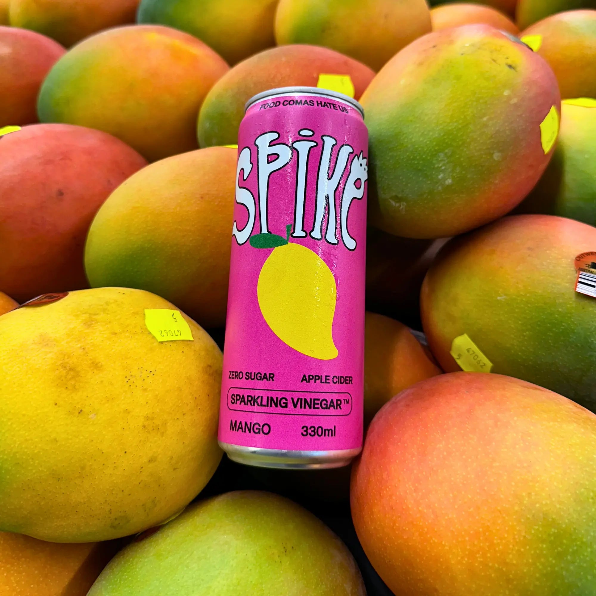 spike Mango sparkling vinegar drink — grocer surrounded by mangos